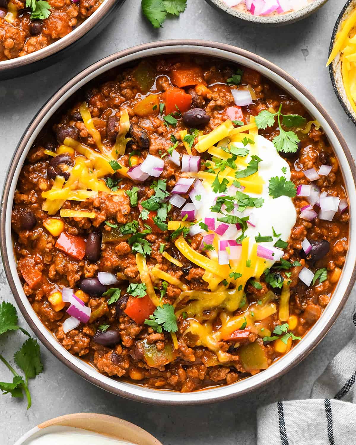 a bowl of Crock Pot Chili garnished with sour cream cheese and cilantro