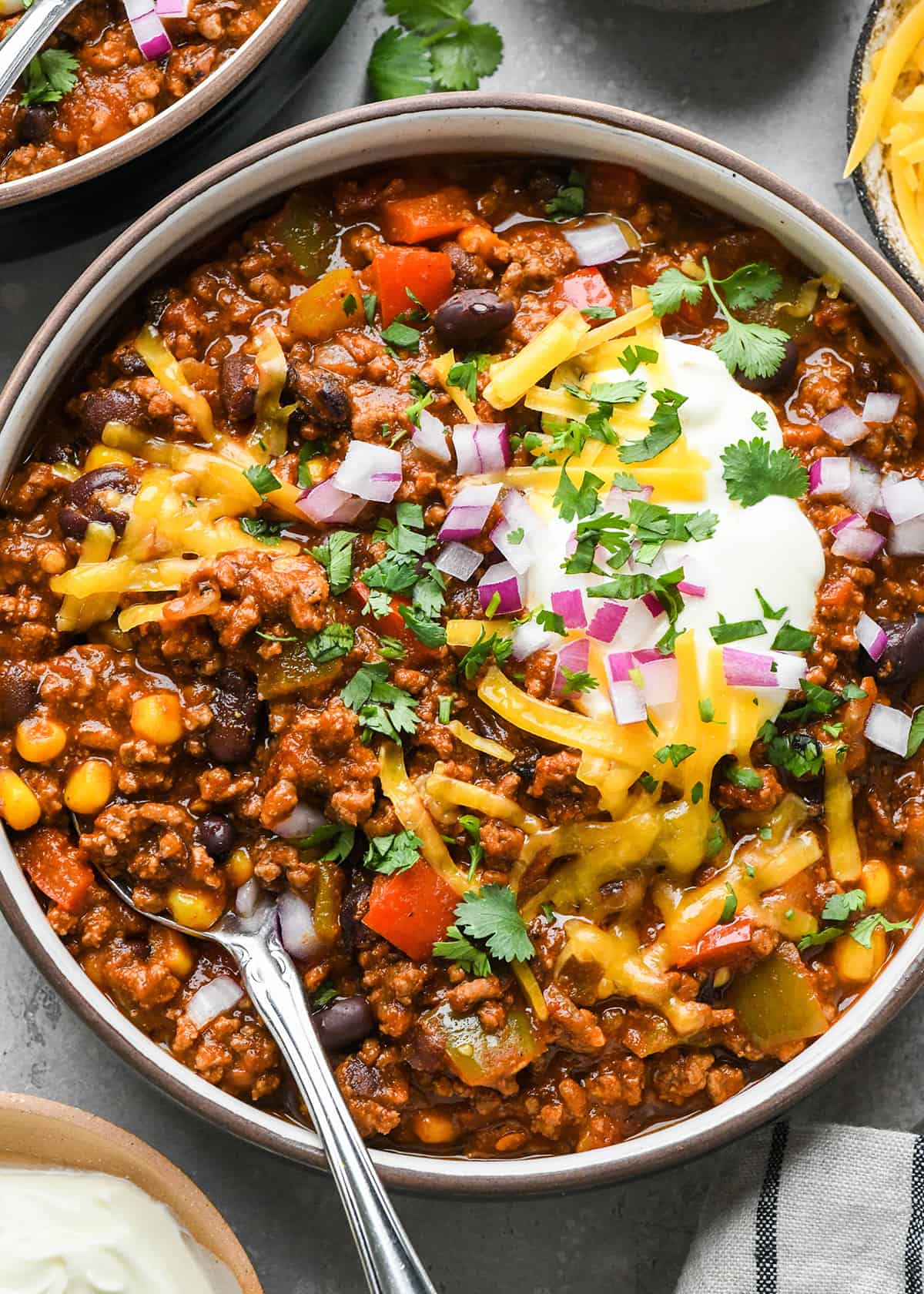 a bowl of Crock Pot Chili garnished with sour cream cheese and cilantro