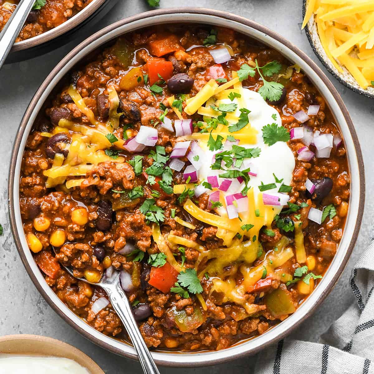 a bowl of Crock Pot Chili garnished with sour cream, cheese and cilantro