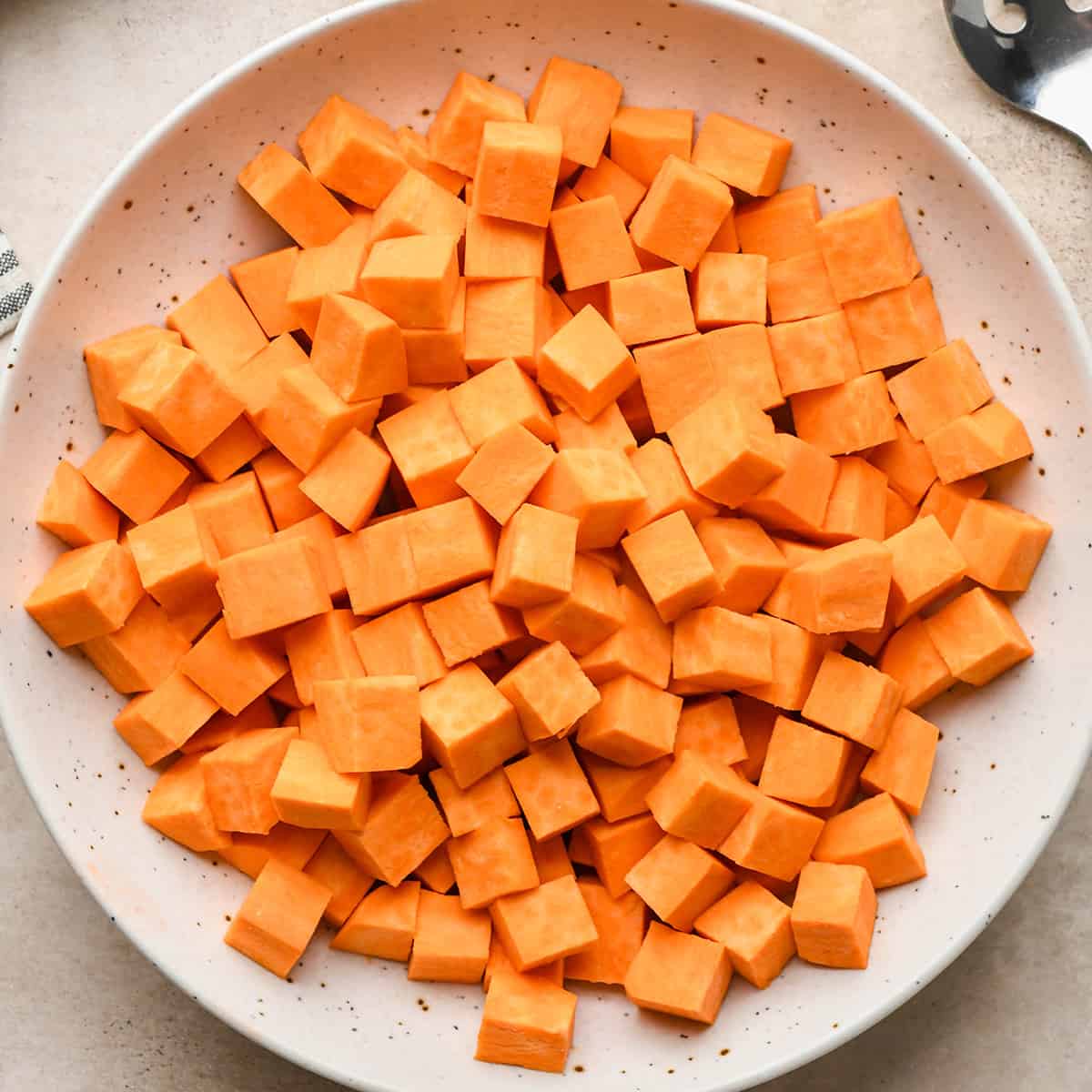 How to Roast Sweet Potatoes - cubed and peeled sweet potatoes in a bowl