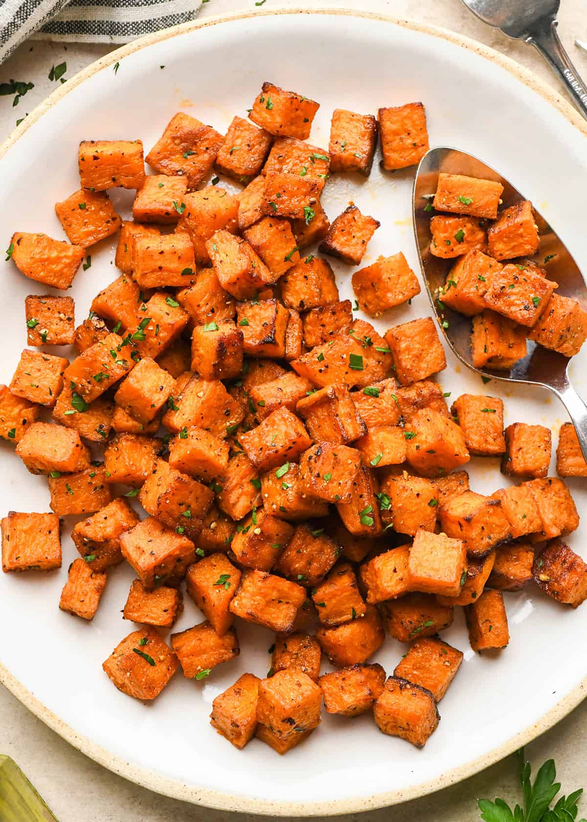  Oven Roasted Sweet Potatoes on a serving plate with a spoon