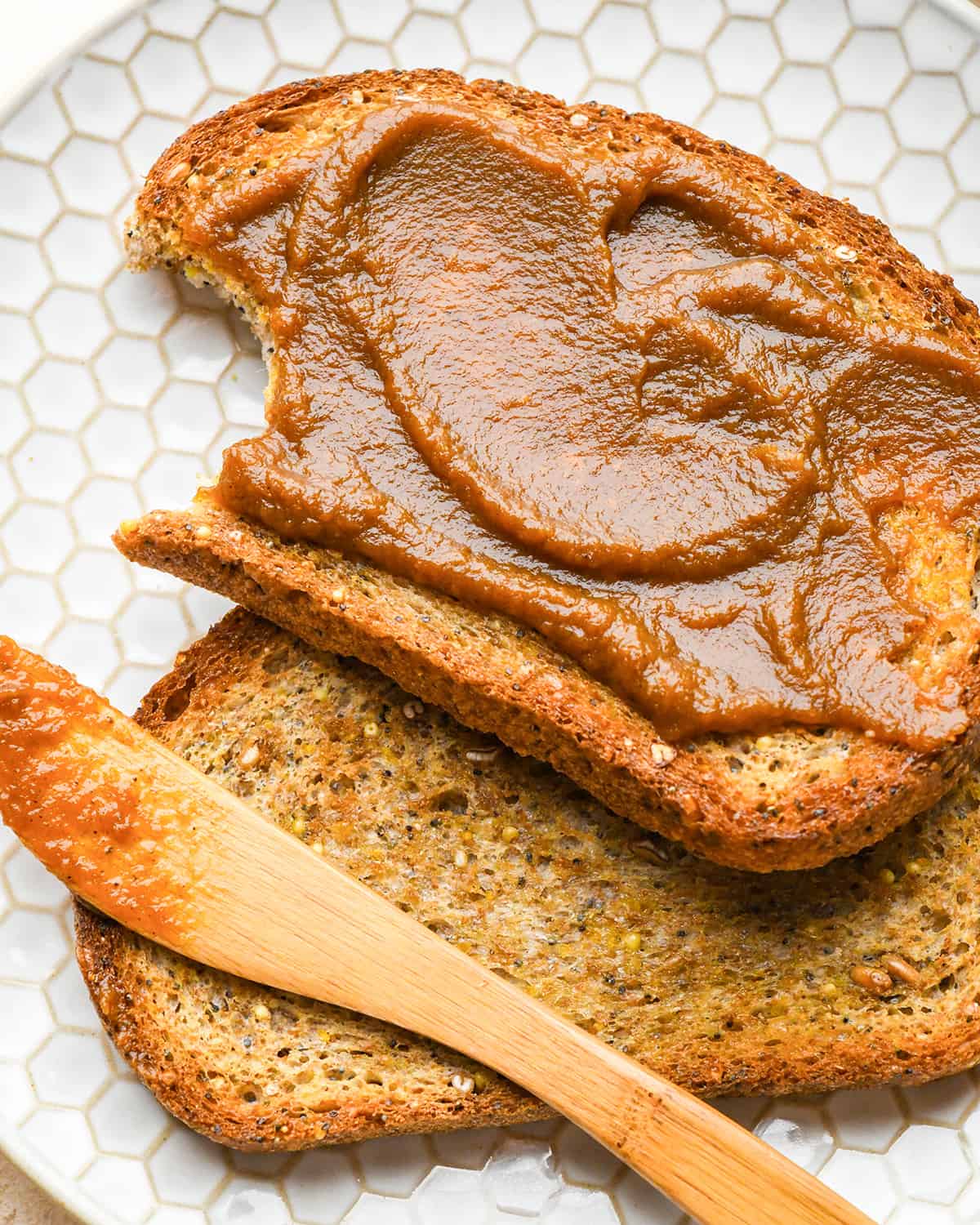 Beurre de citrouille étalé sur du pain grillé avec une bouchée prise