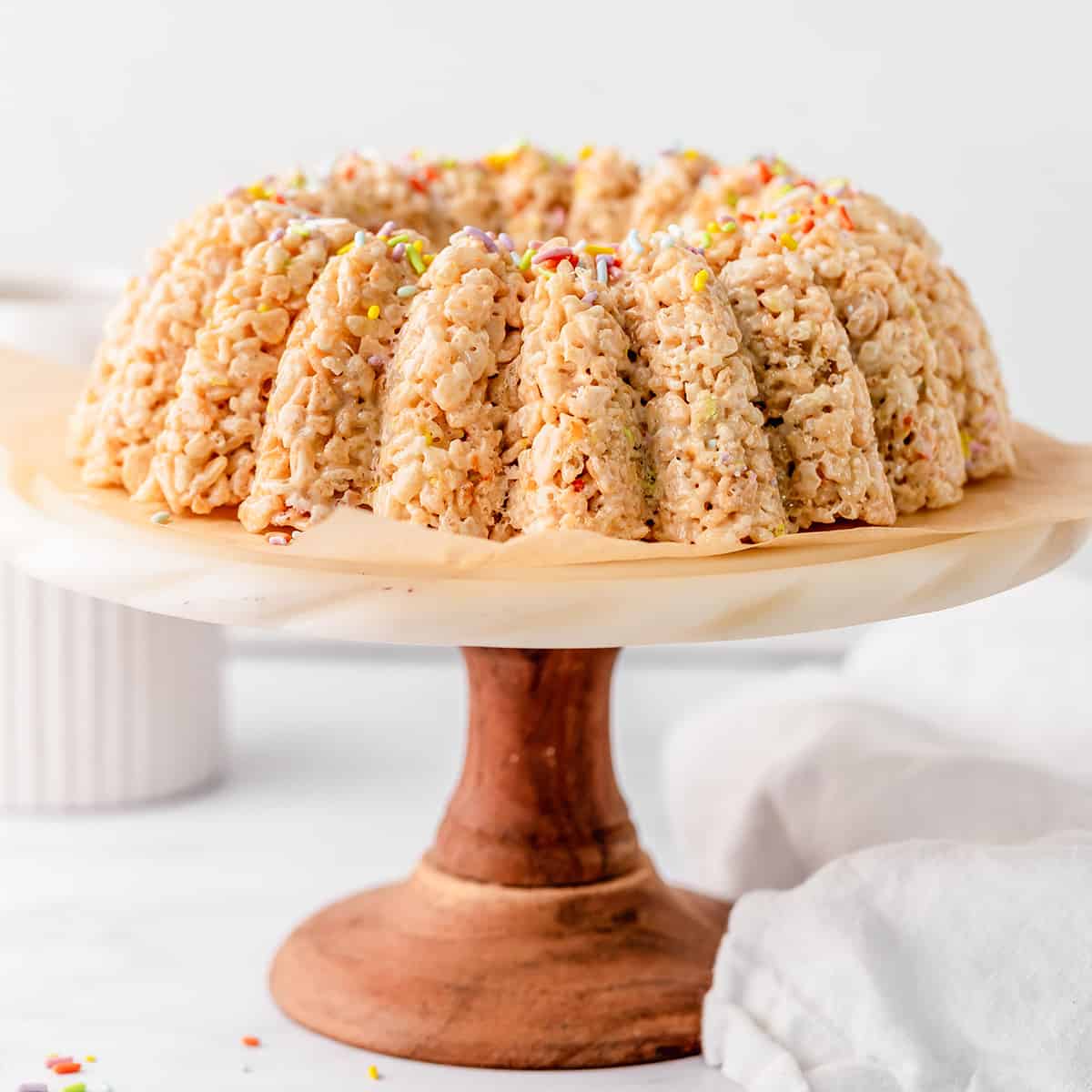 Rice Crispy Cake on a cake plate topped with sprinkles