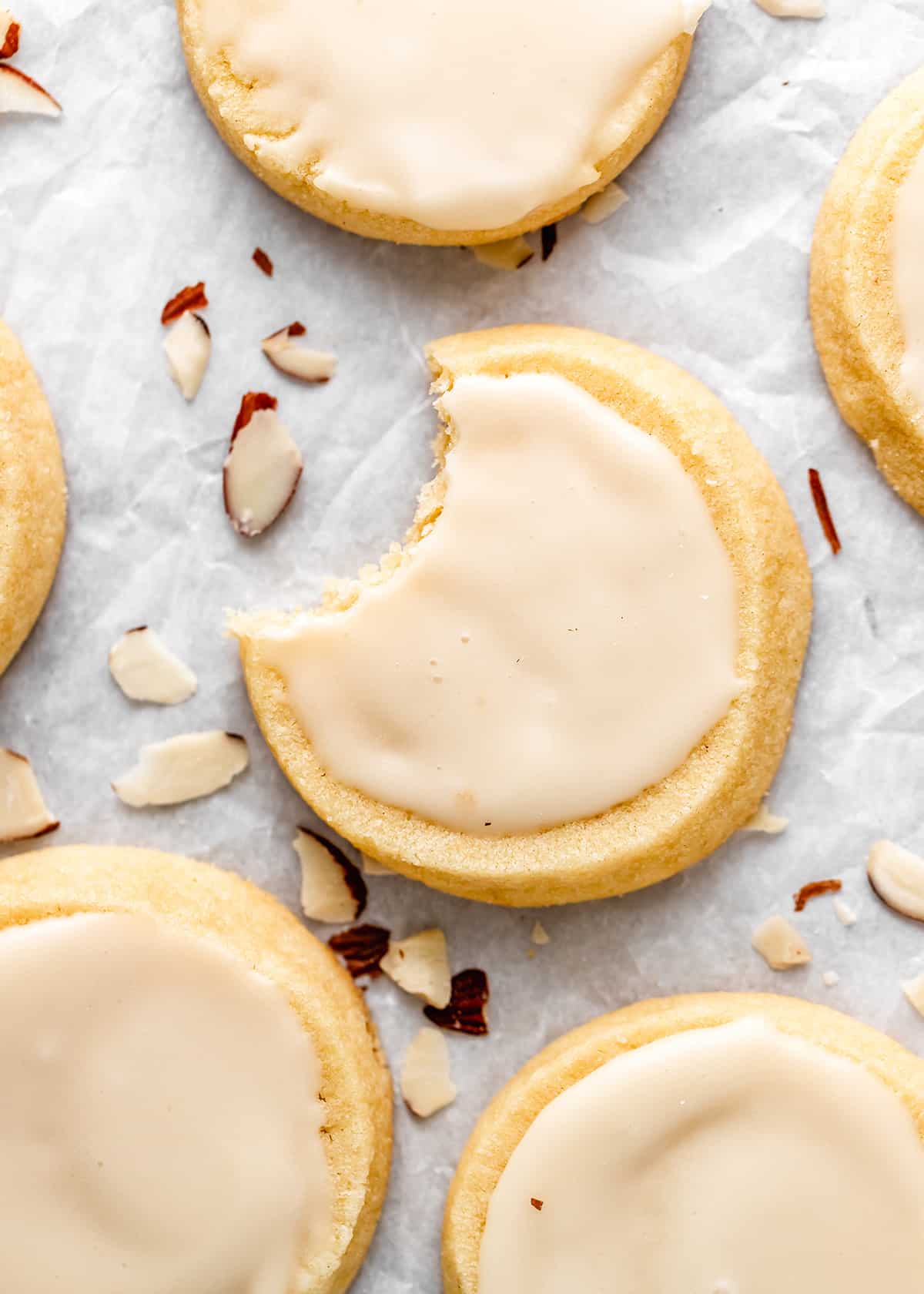 4 Almond Cookies with glaze, one with a bite taken out of it