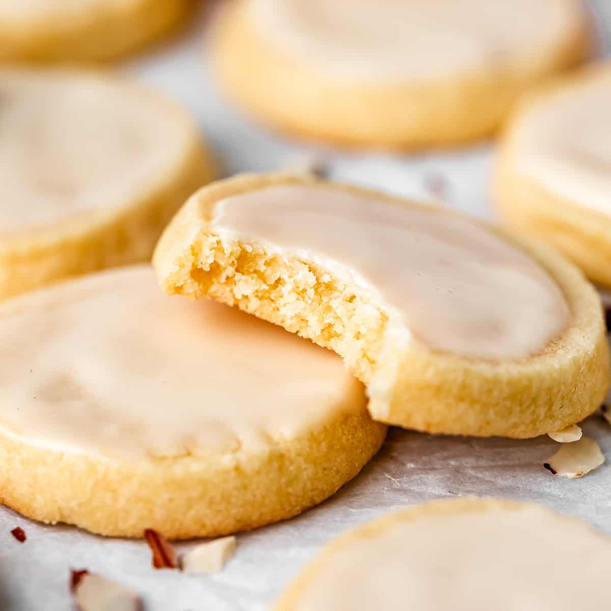 two almond shortbread cookies, one with a bite taken out of it