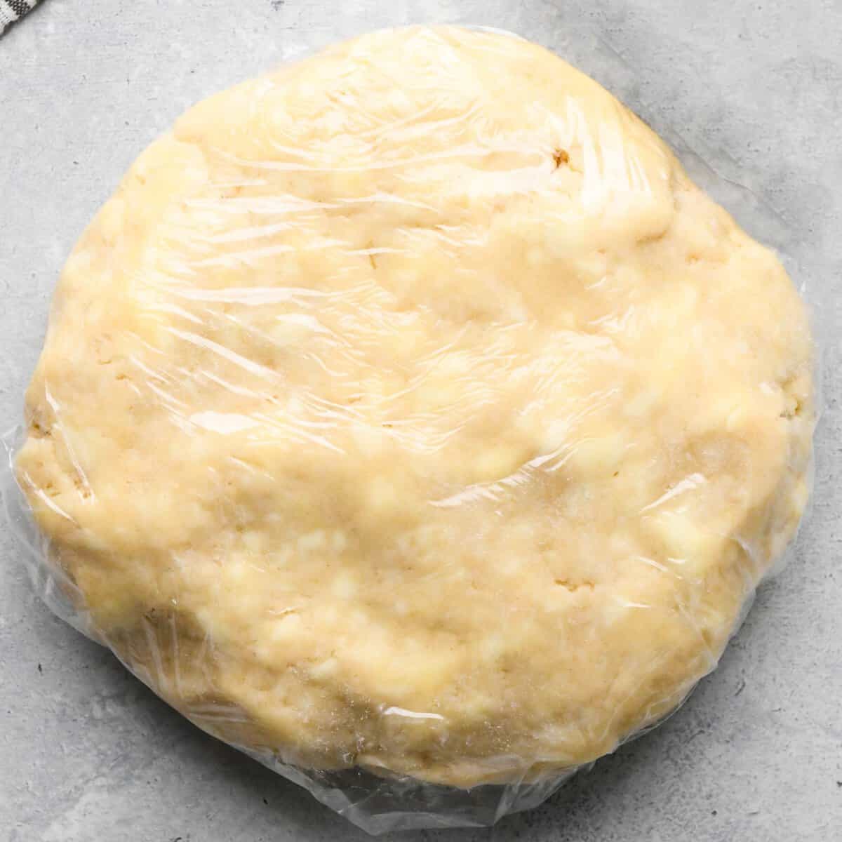 apple crumb pie crust wrapped in plastic wrap to be chilled.