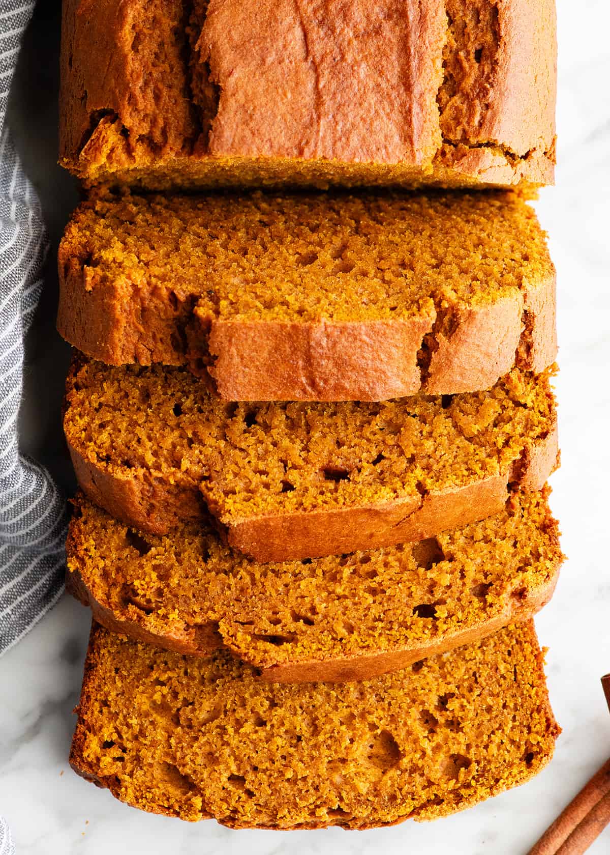 overhead view of a loaf of pumpkin bread with 4 slices cut out of it