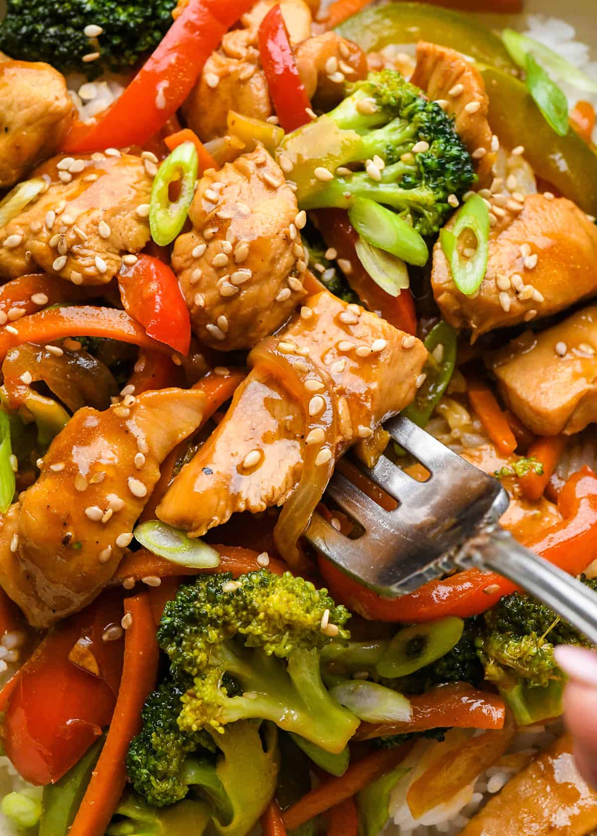 up close photo of a fork taking a bite of Chicken Stir Fry