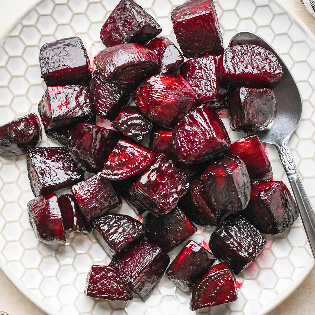 roasted beets on a plate with a spoon