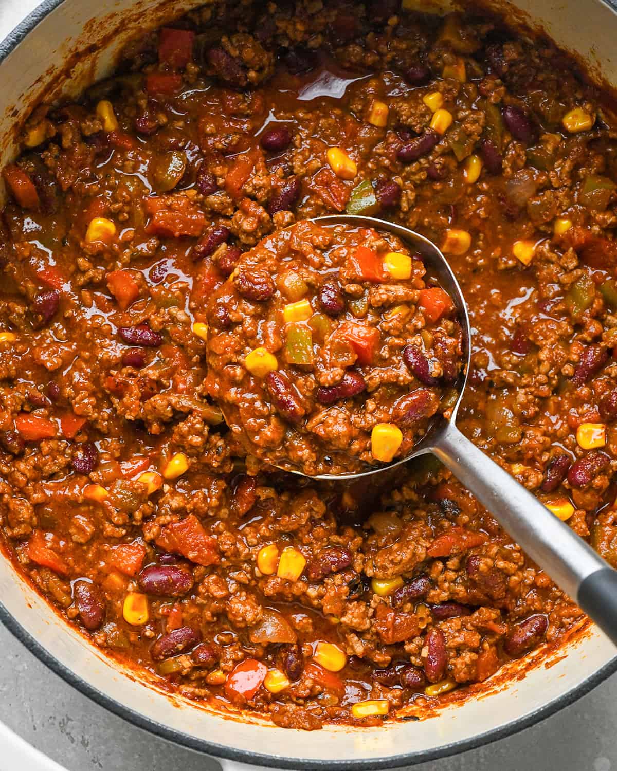 a ladle taking a scoop of Easy Chili Recipe from the pot