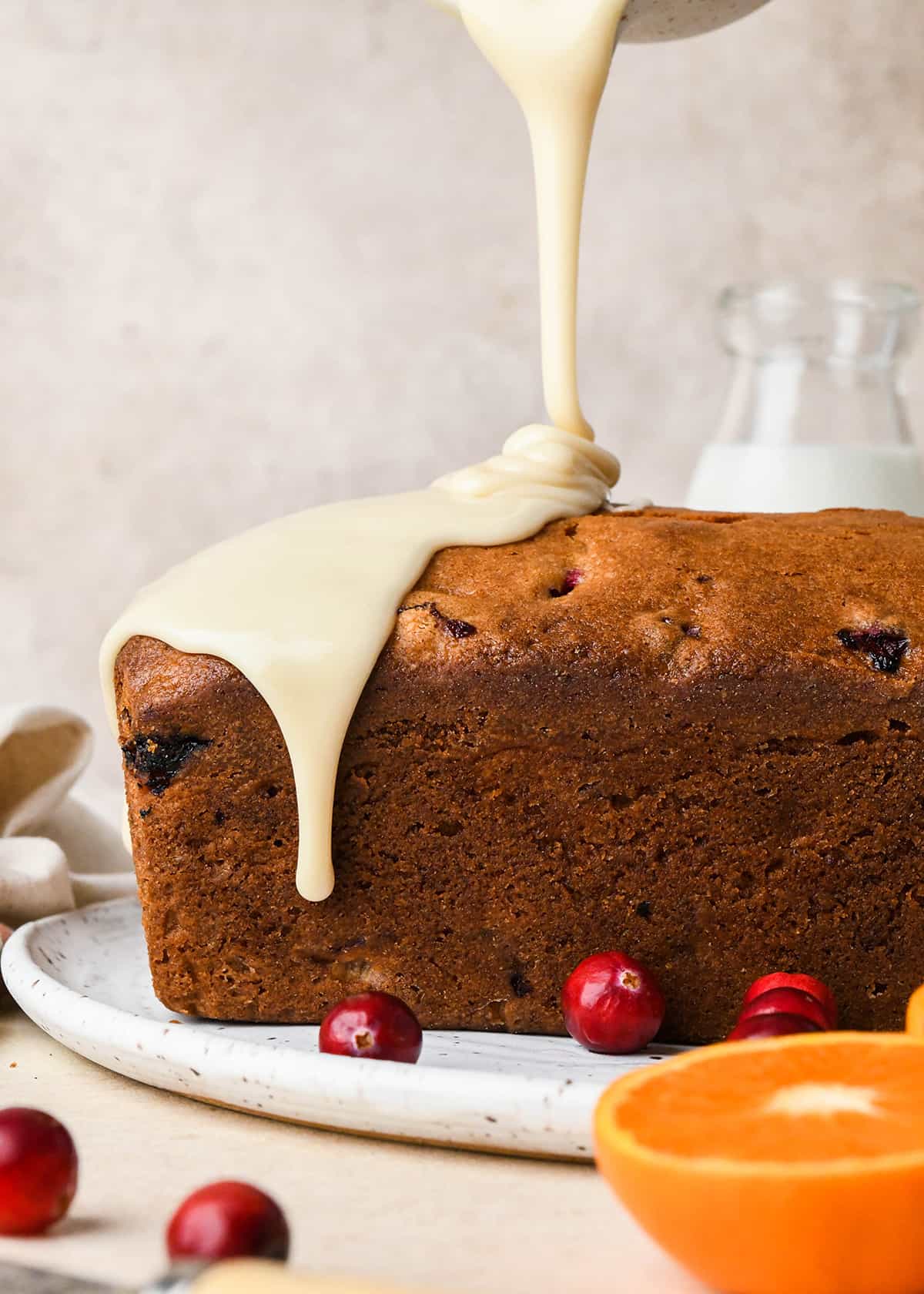 glaze being poured onto Cranberry Orange Bread