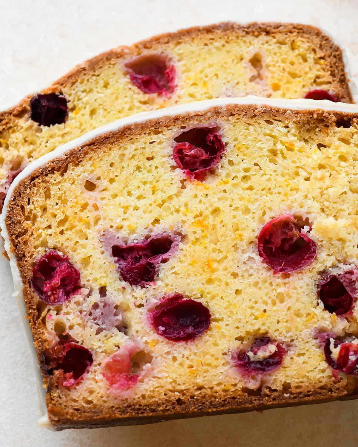 two slices of Cranberry Orange Bread with glaze