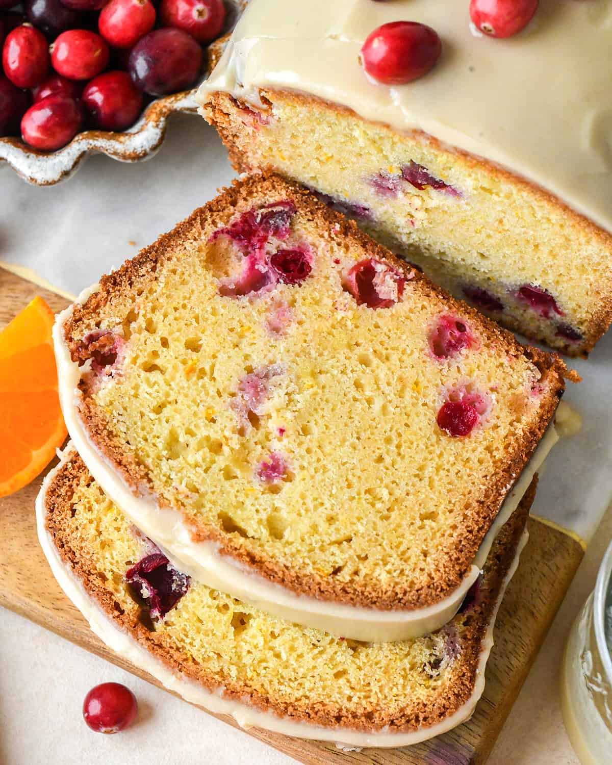 a loaf of Cranberry Orange Bread with 2 slices cut out of it