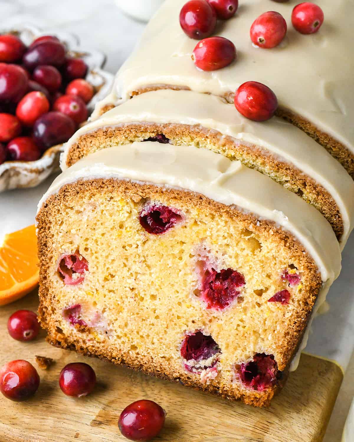 a loaf of Cranberry Orange Bread with 2 slices cut out of it