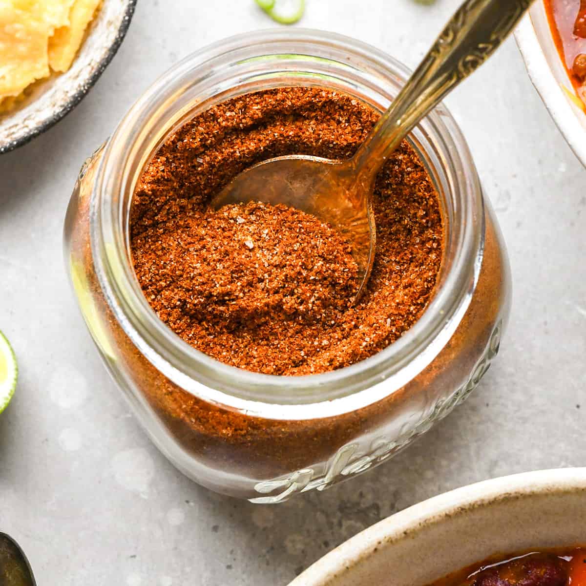 Homemade Chili Seasoning Recipe in a glass jar with a spoon