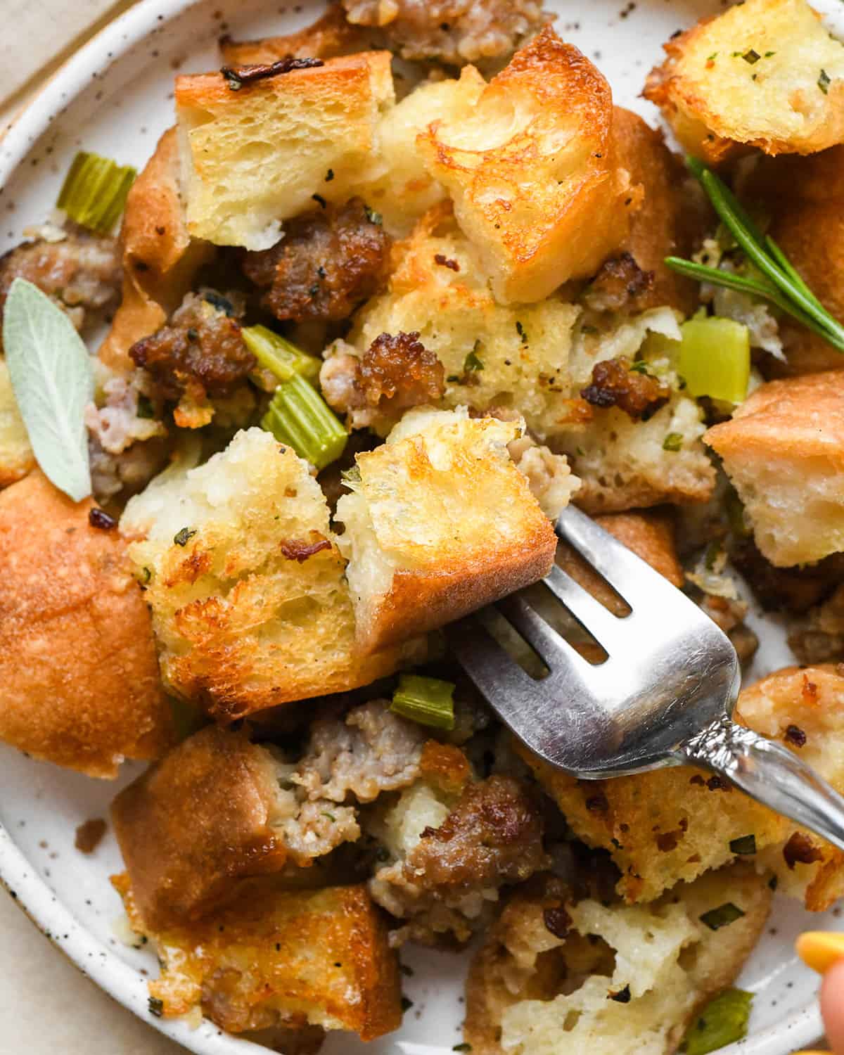 Homemade Stuffing Recipe on a plate with a fork taking a bite