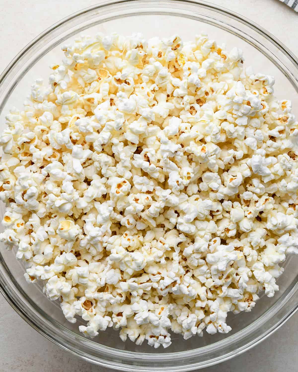 popped popcorn in a large glass bowl