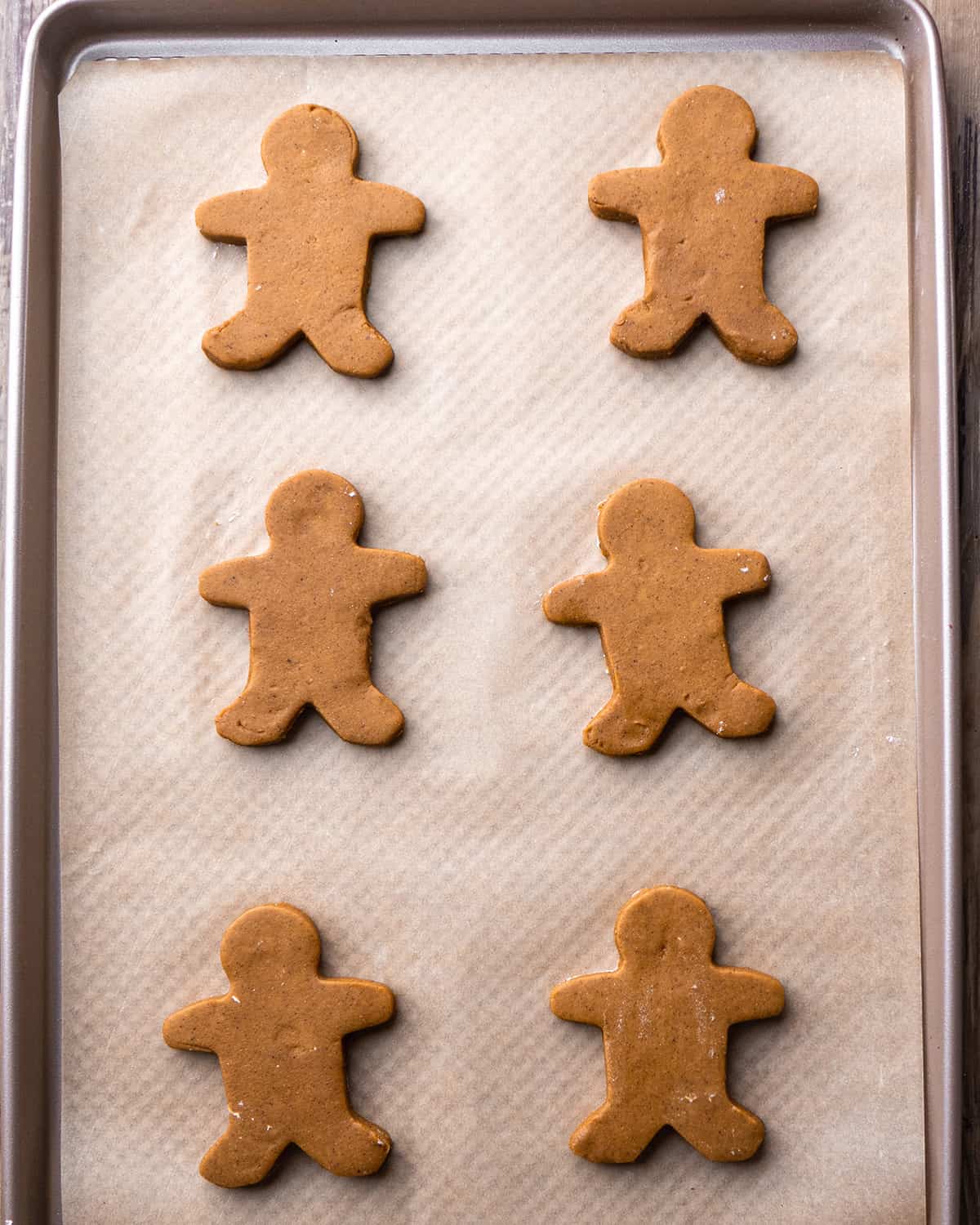 How to Make Gingerbread Men - cut out gingerbread men on a baking sheet before baking
