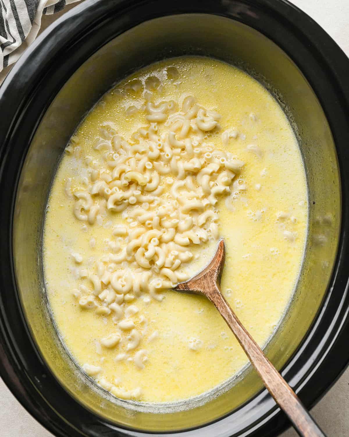 Crock Pot Mac and Cheese being stirred after pasta was cooked