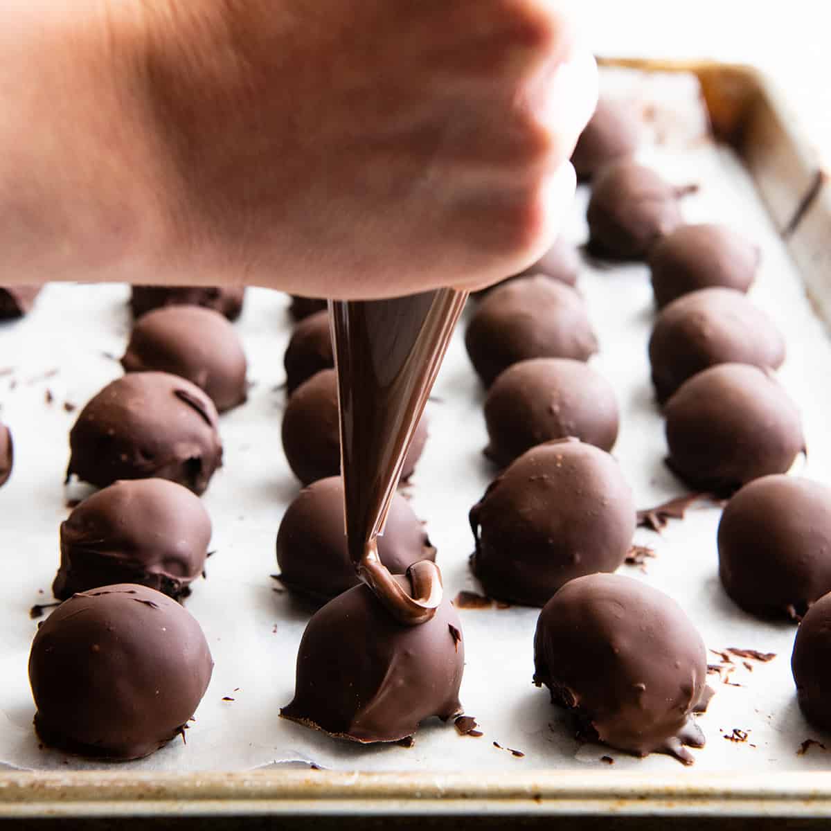 How to Make Oreo Balls drizzling chocolate on top