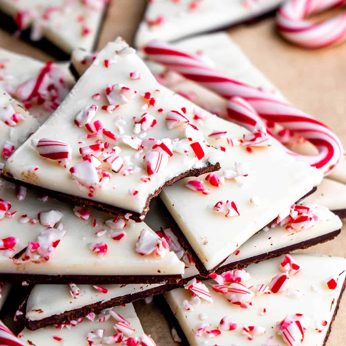 a stack of Homemade Peppermint Bark, the top piece with a bite taken out of it