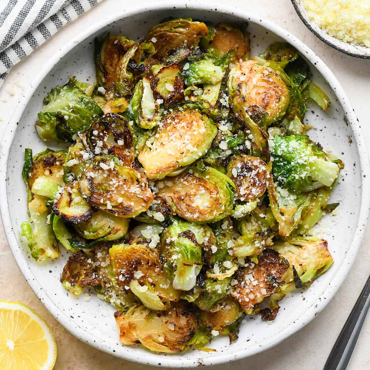 Sautéed Brussels Sprouts on a plate garnished with parmesan cheese