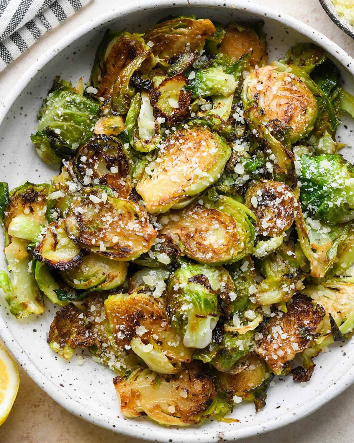 Sautéed Brussels Sprouts on a plate garnished with parmesan cheese