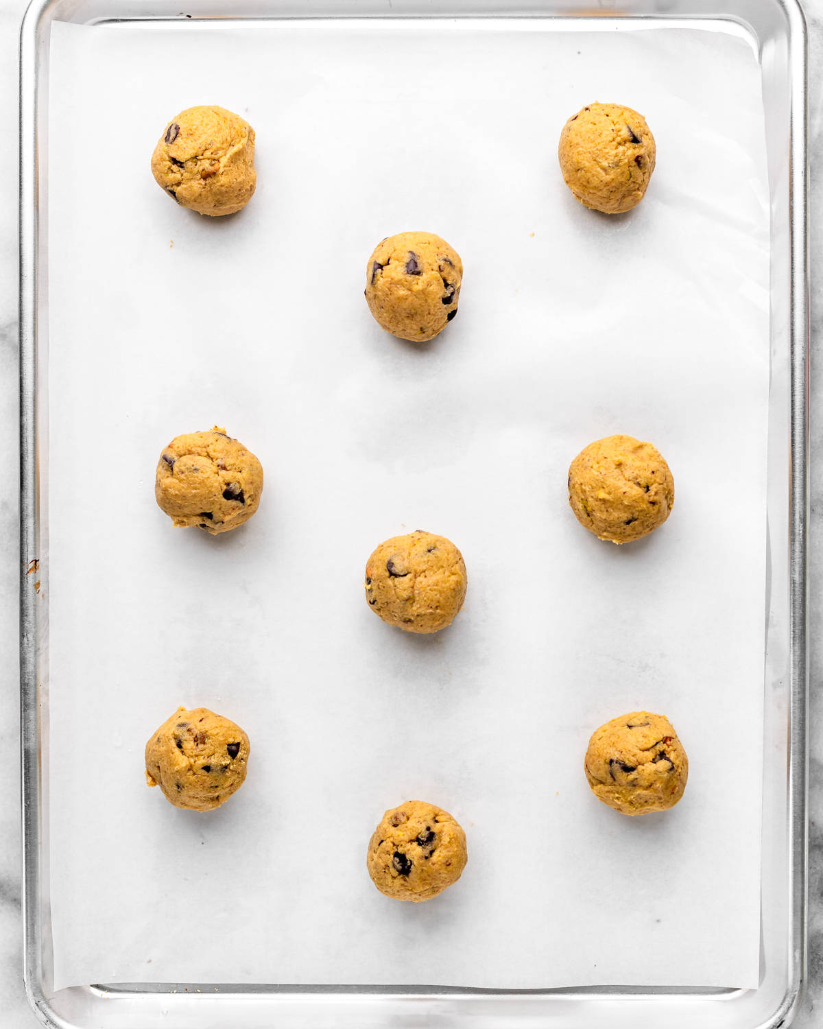 pistachio cookie dough balls on a baking sheet before baking