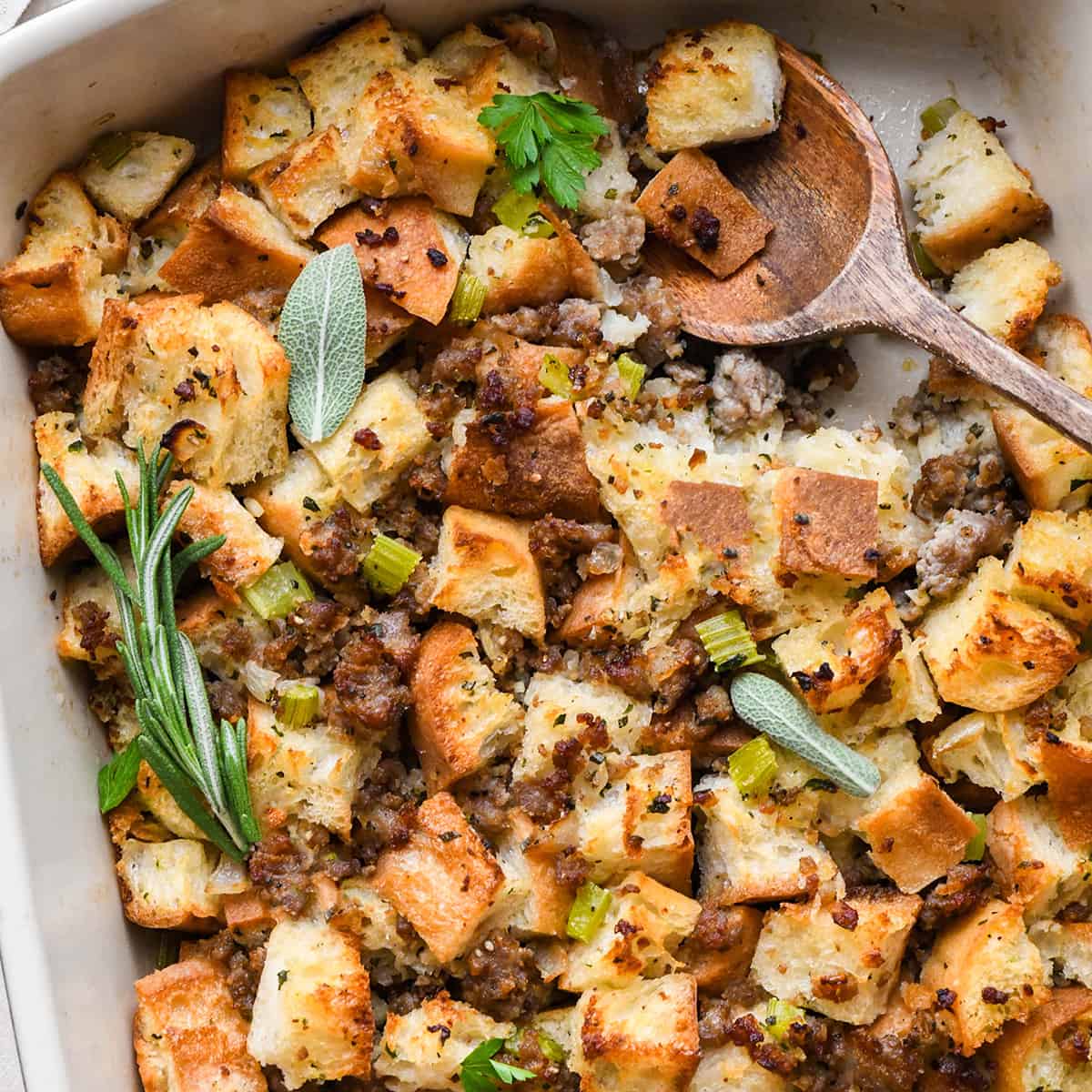 bread stuffing from scratch in a baking dish with a wooden spoon