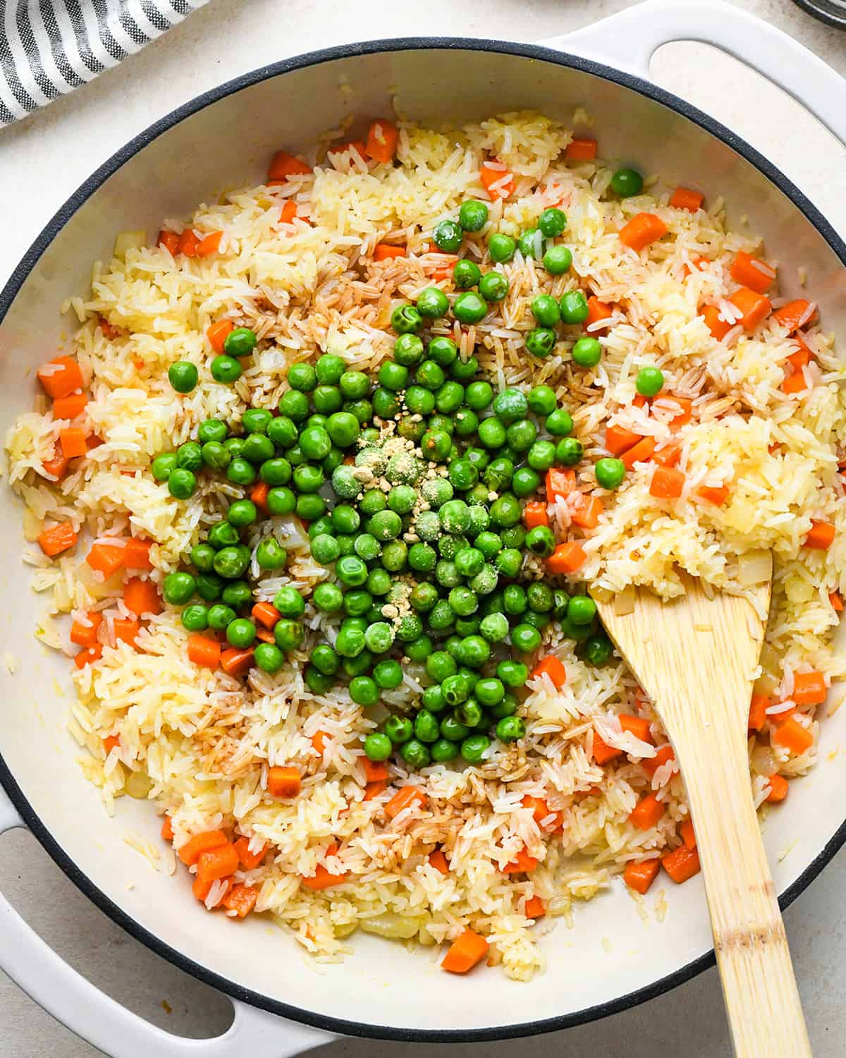 How to Make Fried Rice - adding peas, soy sauce and seasonings before mixing