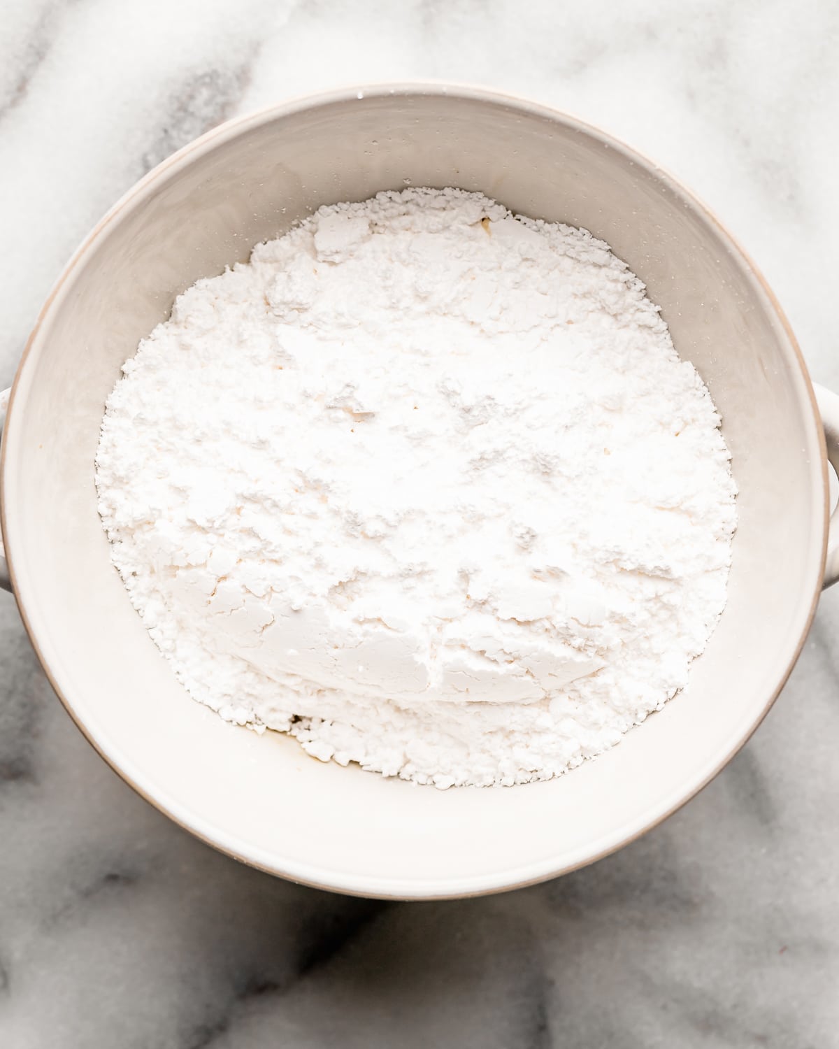 making Maple Glaze in a bowl - adding powdered sugar