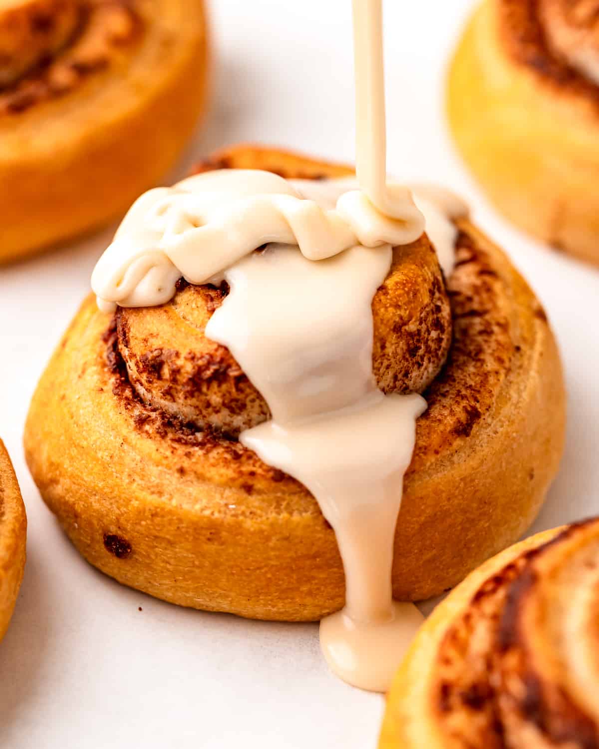 Maple Glaze being poured on a cinnamon roll