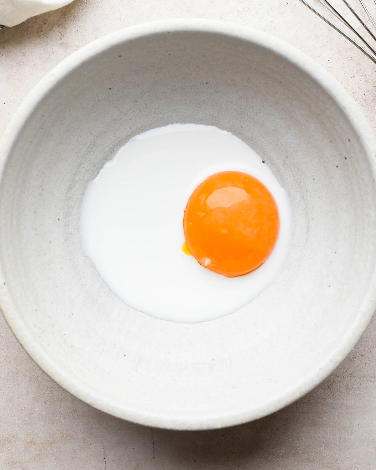 egg yolk and milk in a bowl before mixing