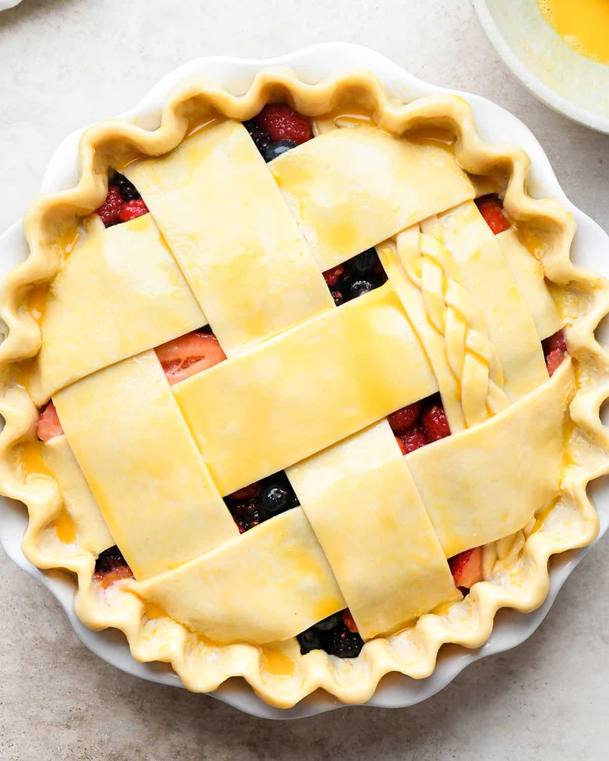 mixed berry pie with egg wash before baking