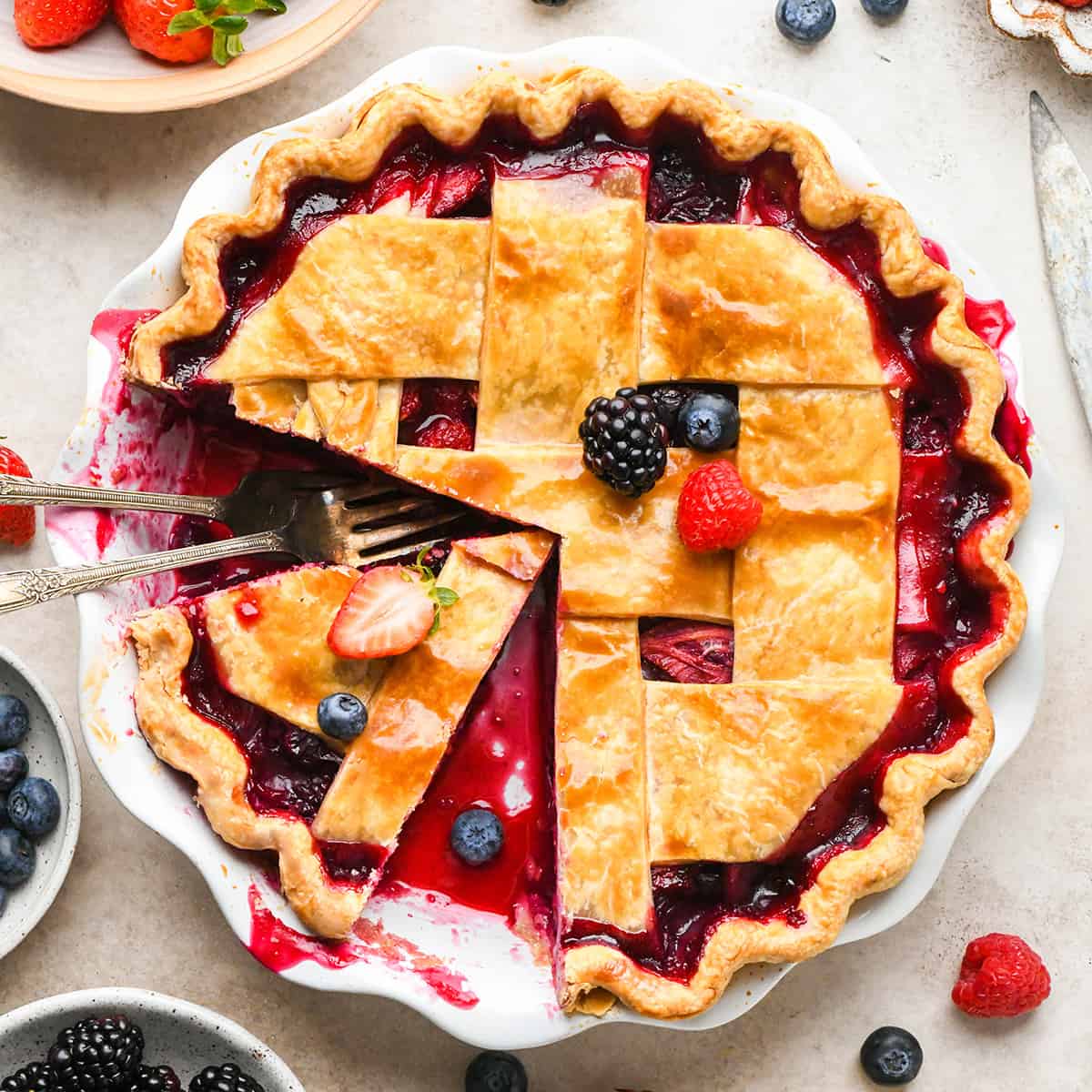 Mixed Berry Pie in a ie dish with a piece cut out of it