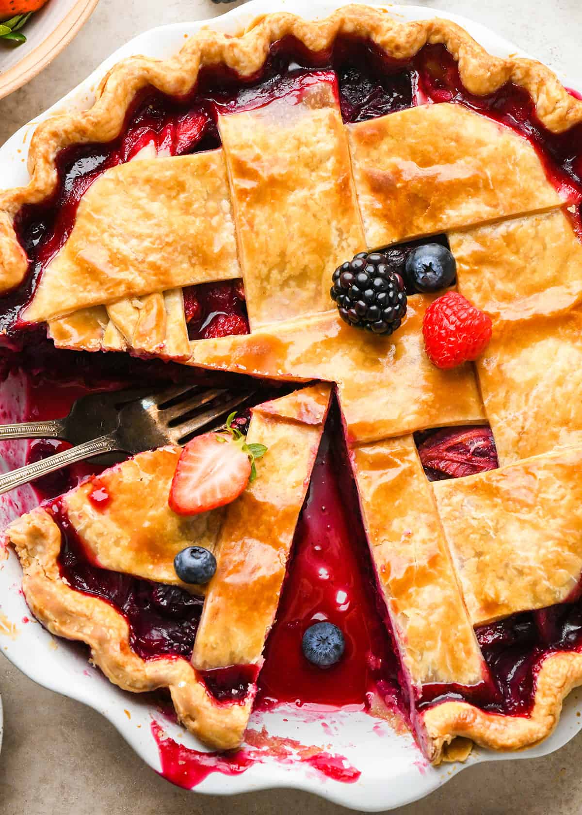 Mixed Berry Pie in a pie dish with a slice cut out