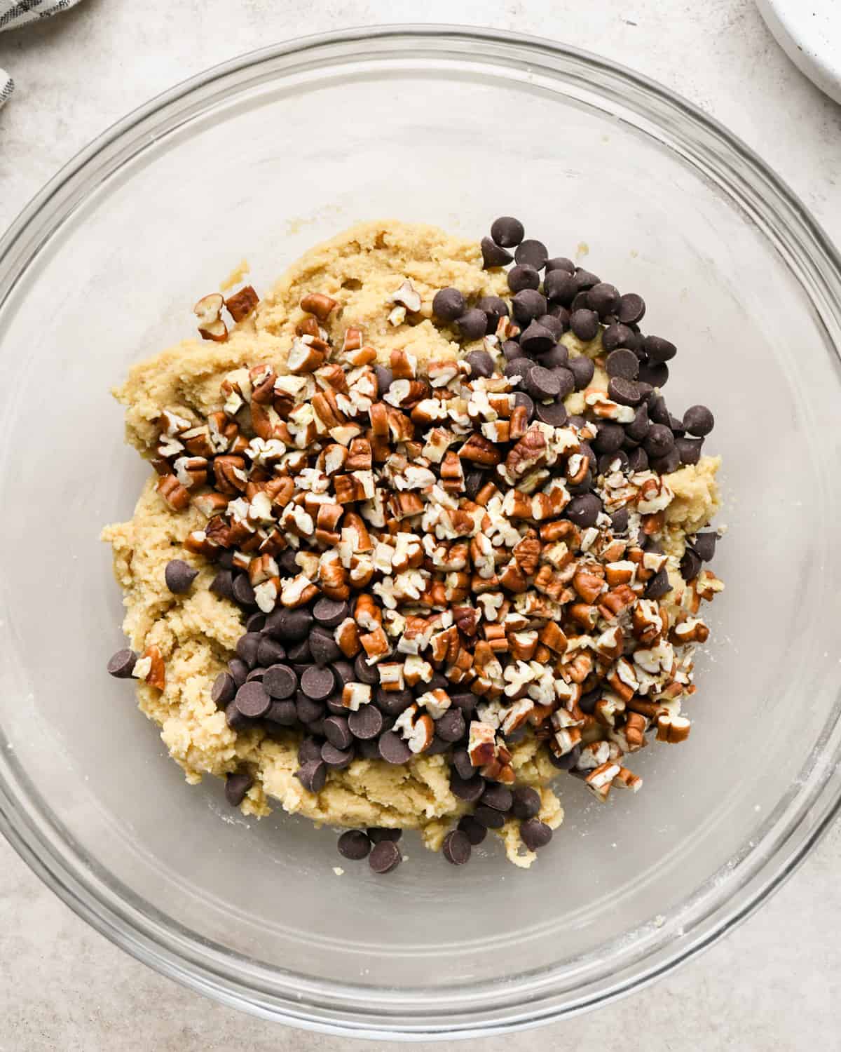 making Chocolate Chip Pecan Cookies - adding pecans and chocolate chips before stirring