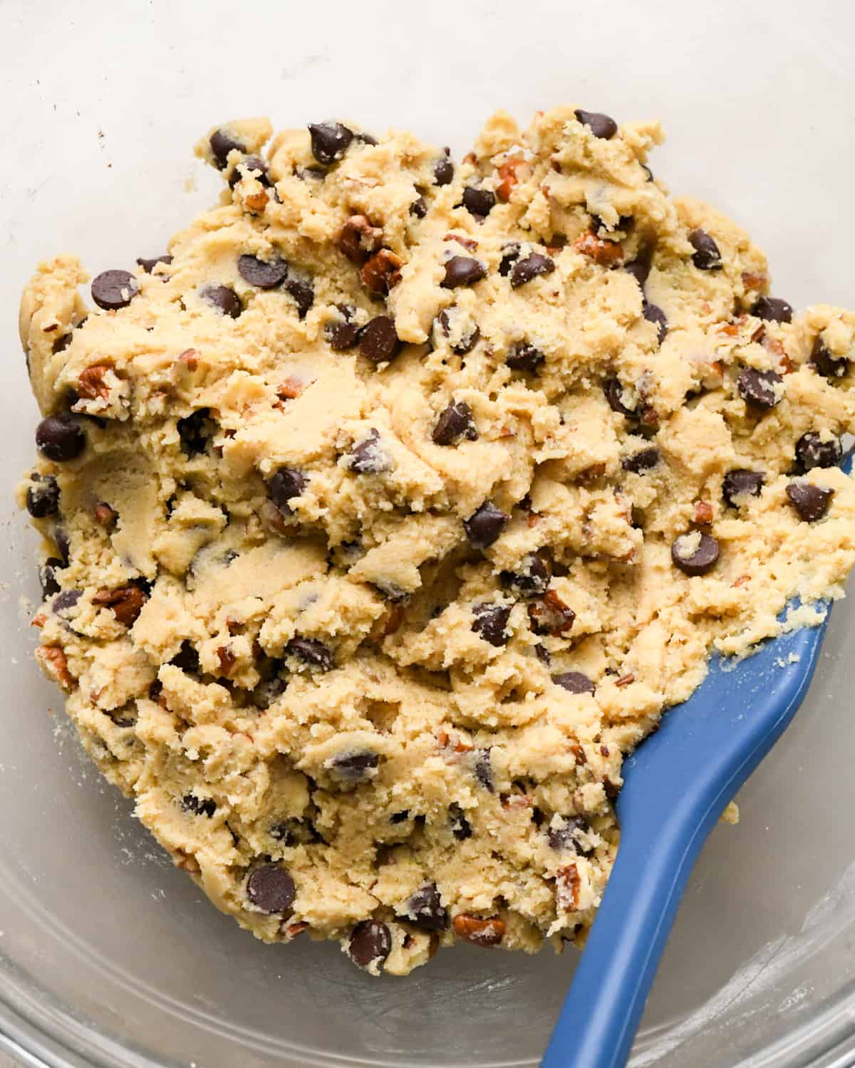 Chocolate Chip Pecan Cookie dough in a bowl with a spatula