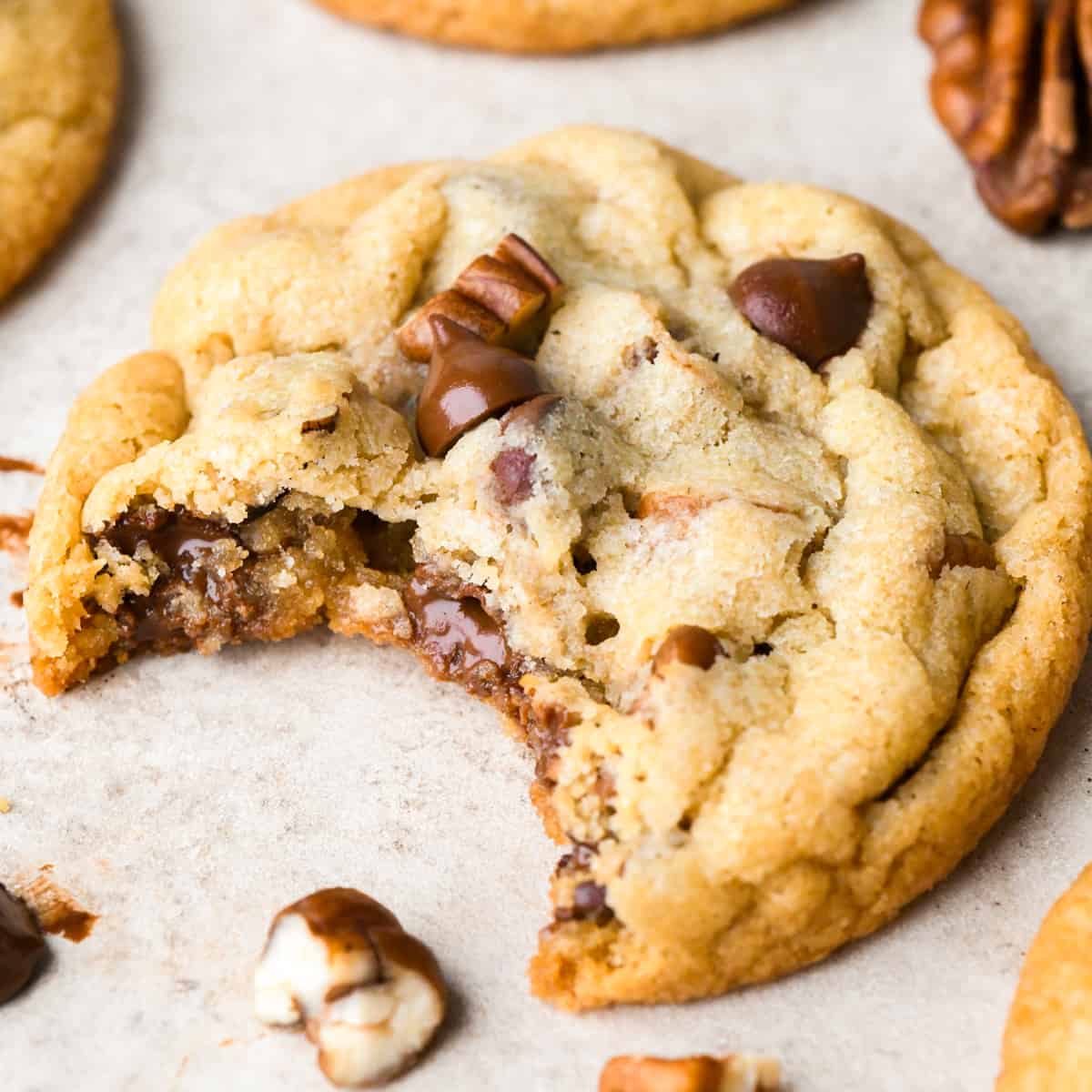 a pecan chocolate chip cookie with a bite taken out of it