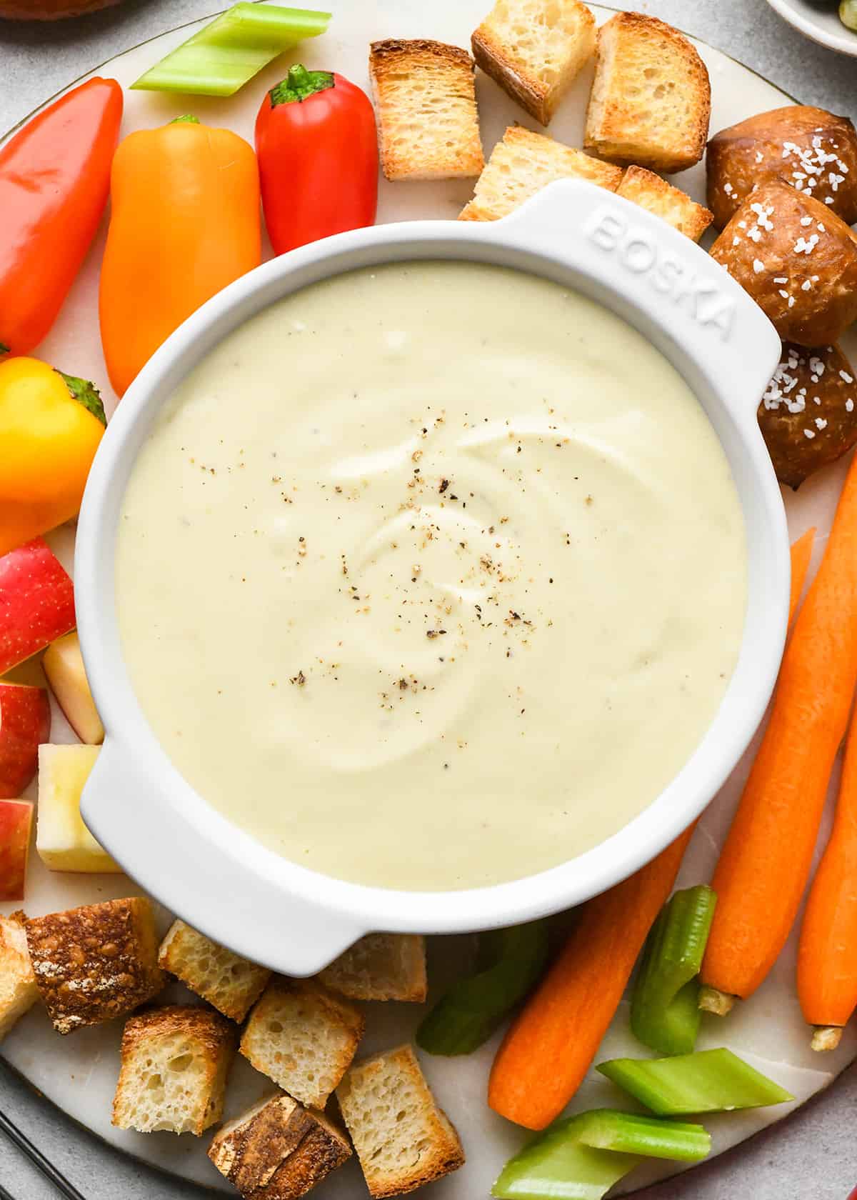 Cheese Fondue Recipe in a serving bowl surrounded by Cheese Fondue dippers