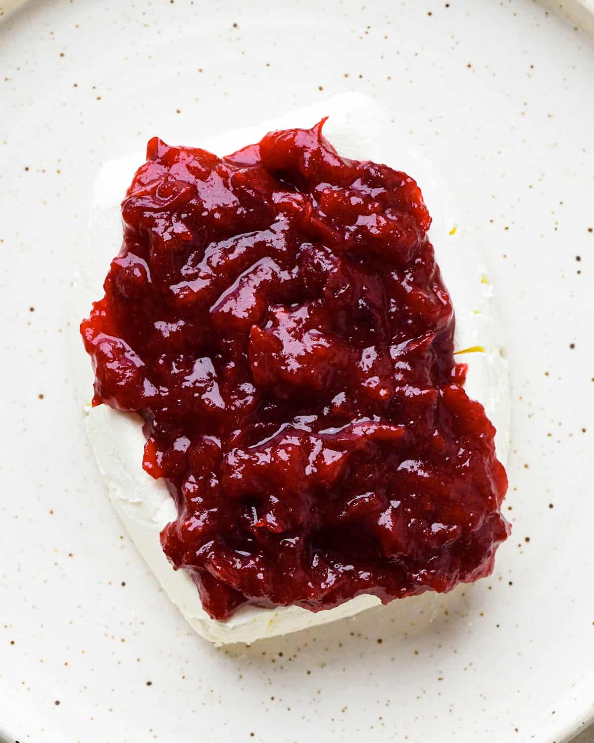 assembling Cranberry Cream Cheese Dip - putting cranberry mixture on top of cream cheese