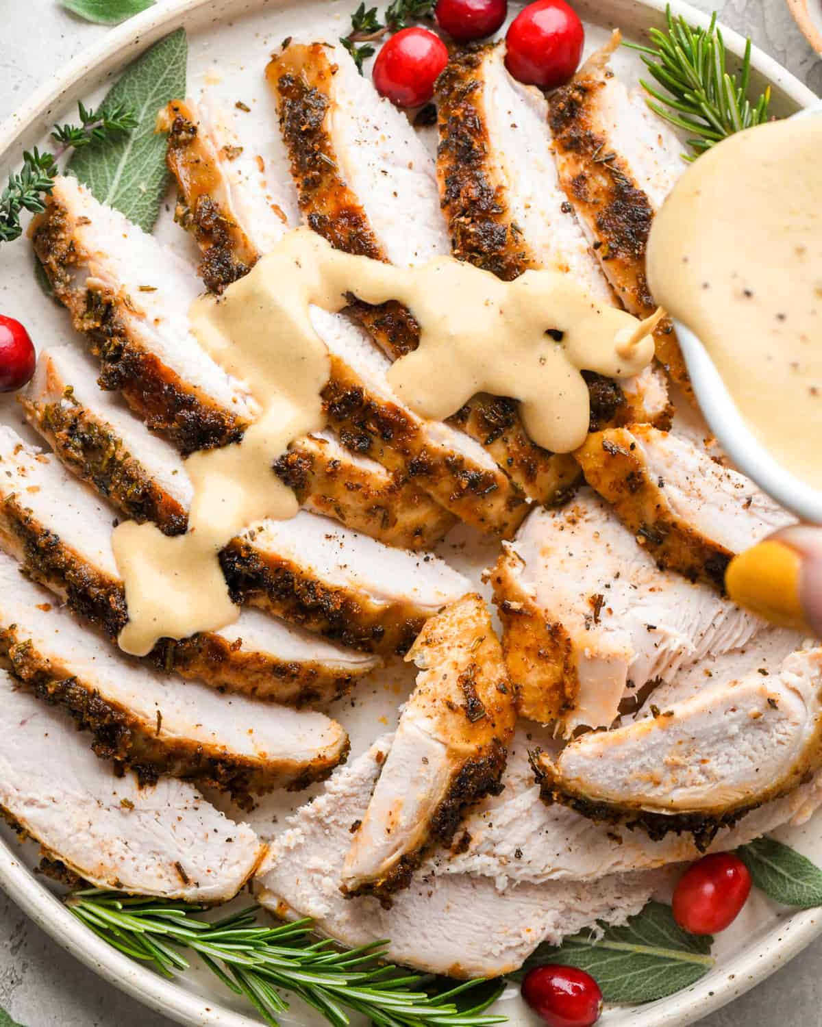 gravy being poured over sliced Crock Pot Turkey Breast on a serving plate