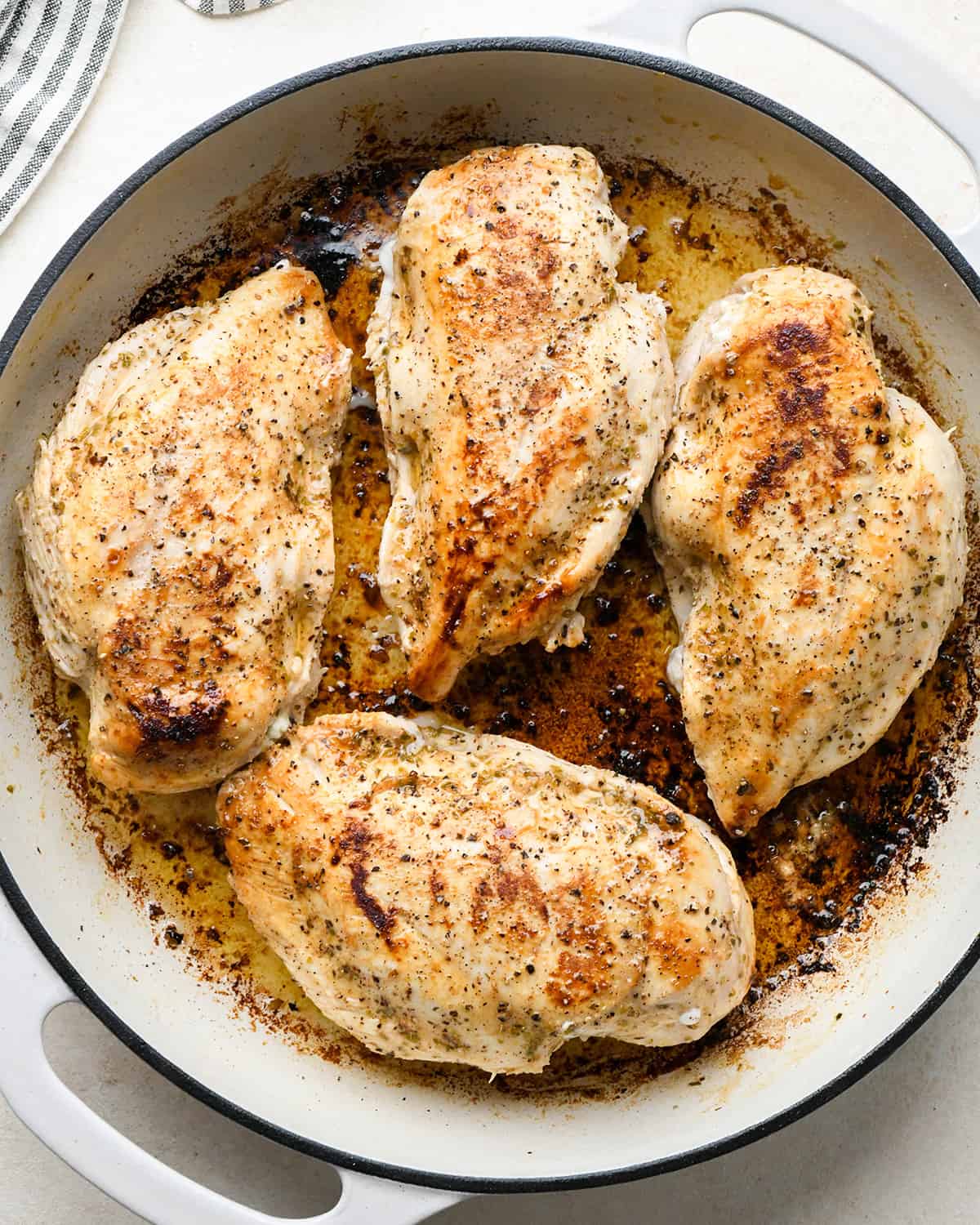 cooking greek stuffed chicken breasts in a skillet on the second side