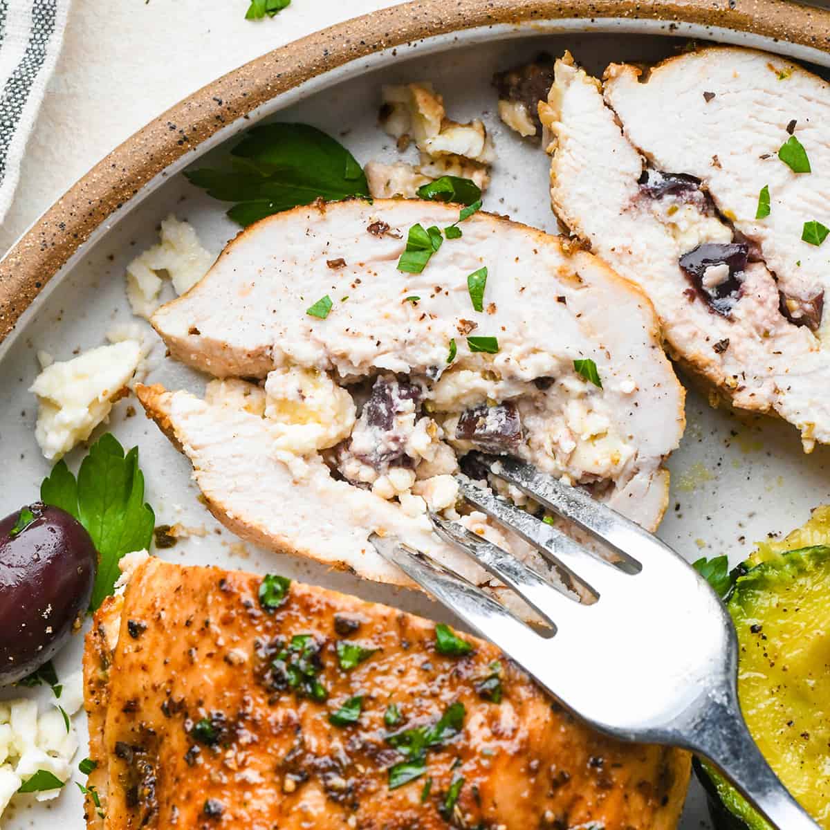 one Feta Stuffed Chicken Breast with a fork taking a bite 