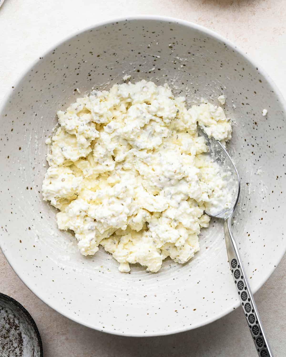 making the filling for Feta Stuffed Chicken Breasts in a bowl after mixing