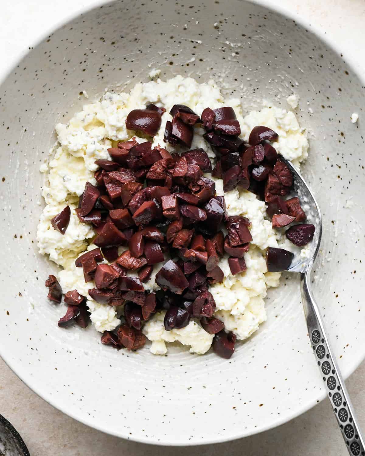 making filling for Feta Stuffed Chicken Breasts - adding olives