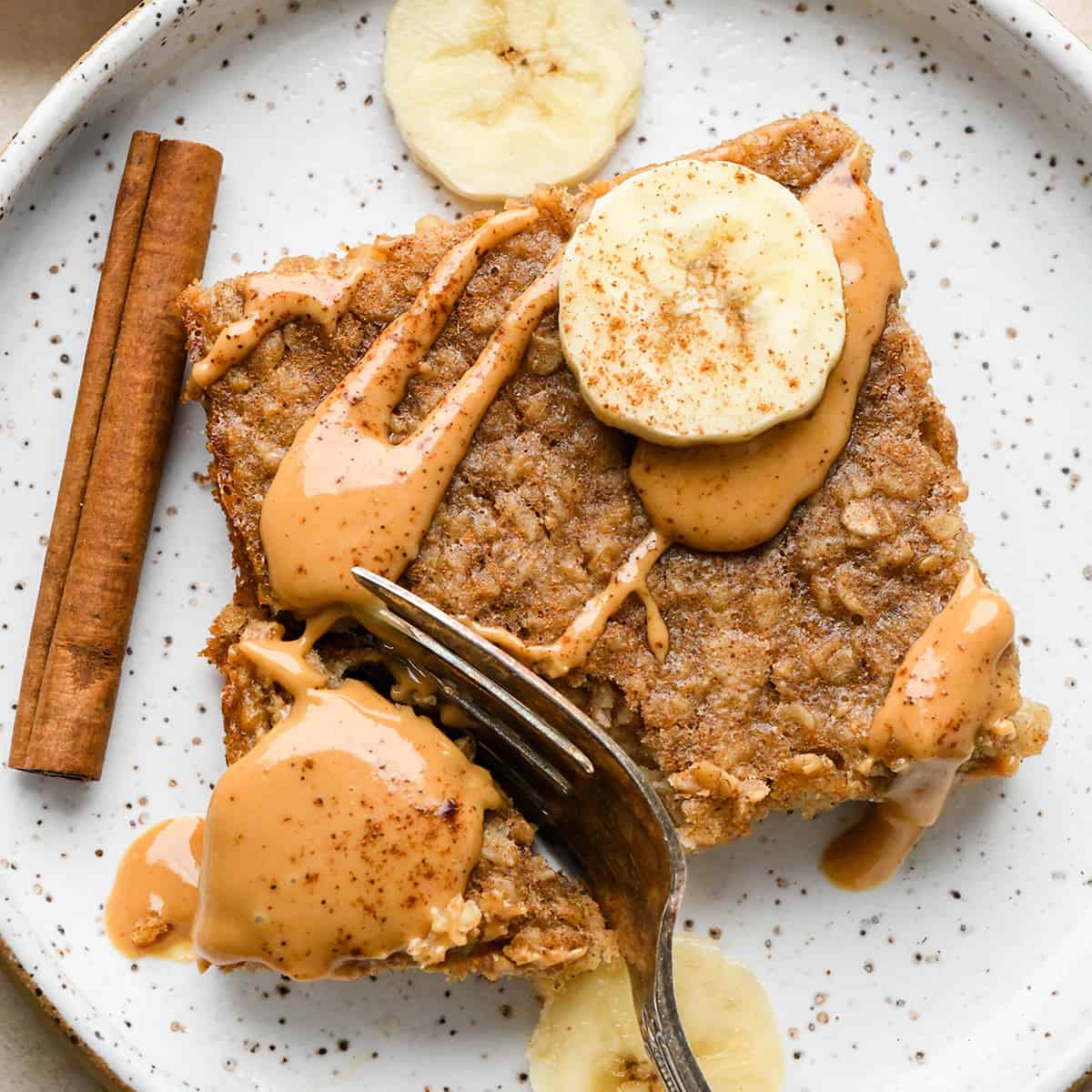 a fork taking a bite of a piece of Peanut Butter Banana Baked Oatmeal on a plate