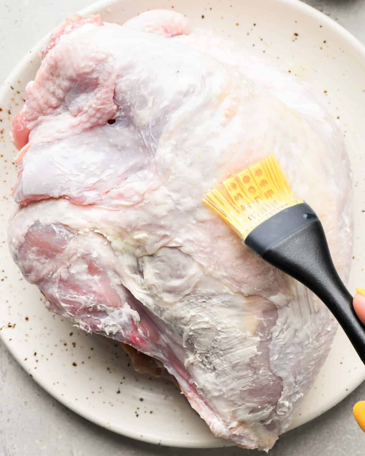 brushing the outside of a turkey breast with olive oil 