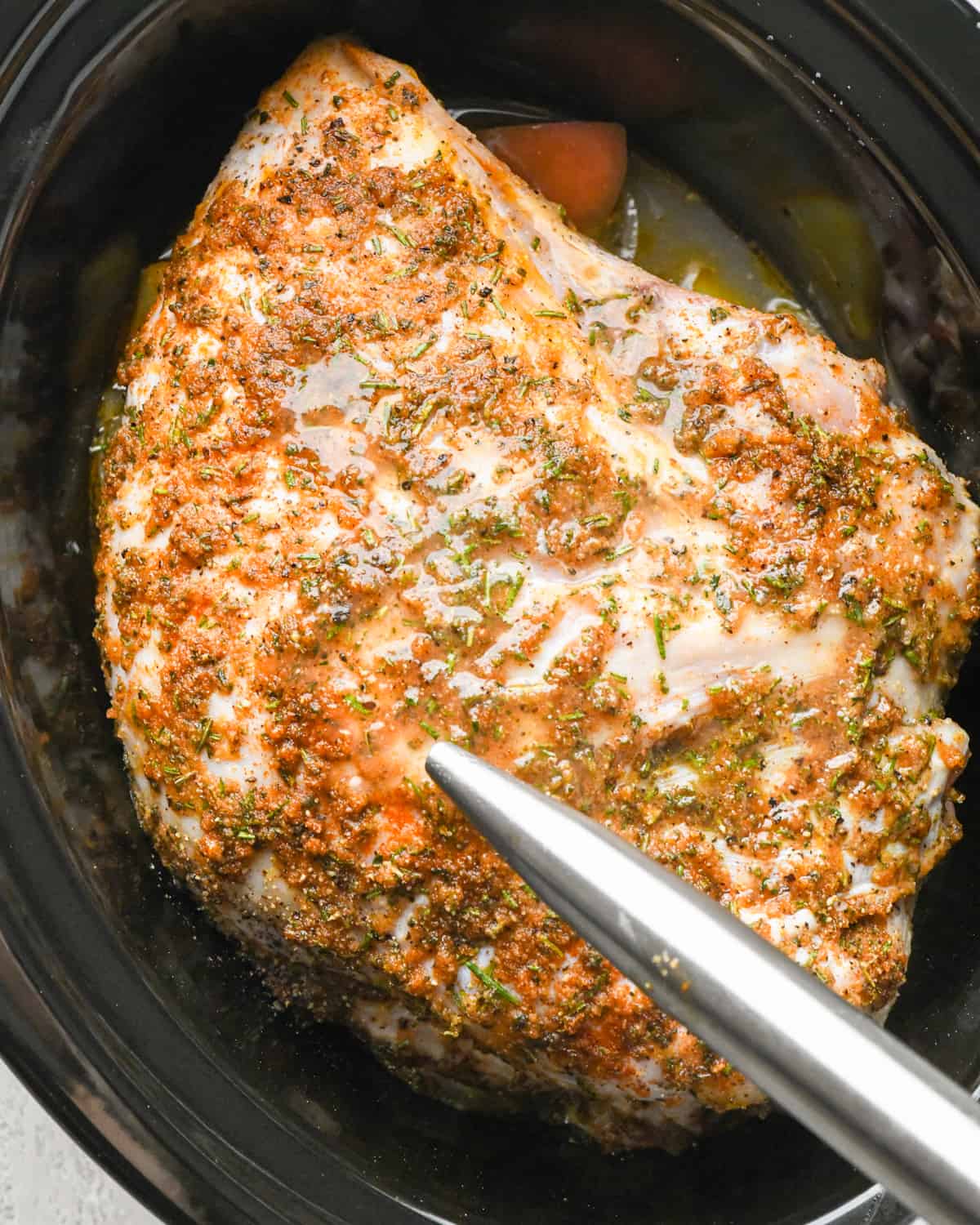 basting a partially cooked Slow Cooker Turkey Breast