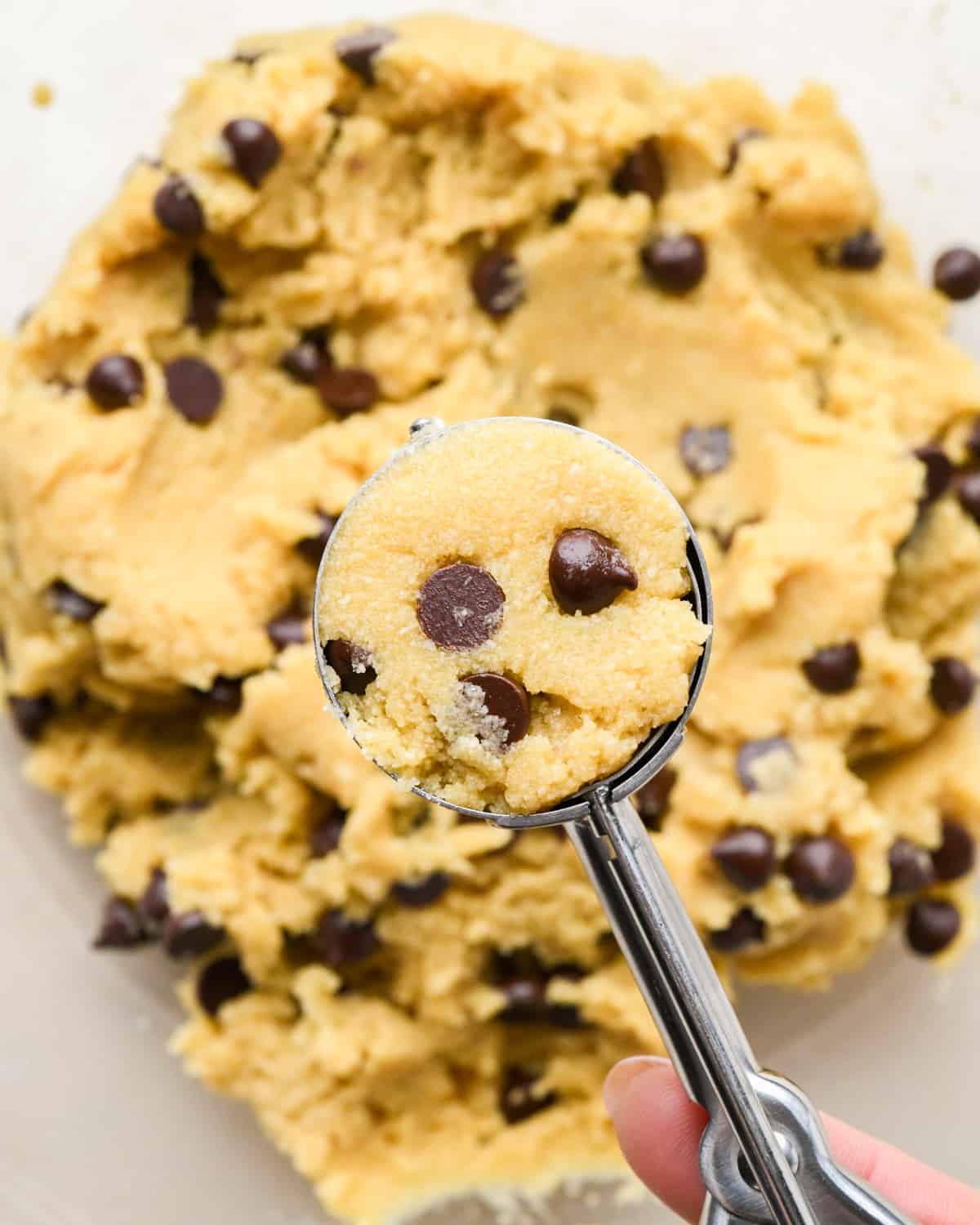 a cookie scoop measuring almond flour chocolate chip cookies dough